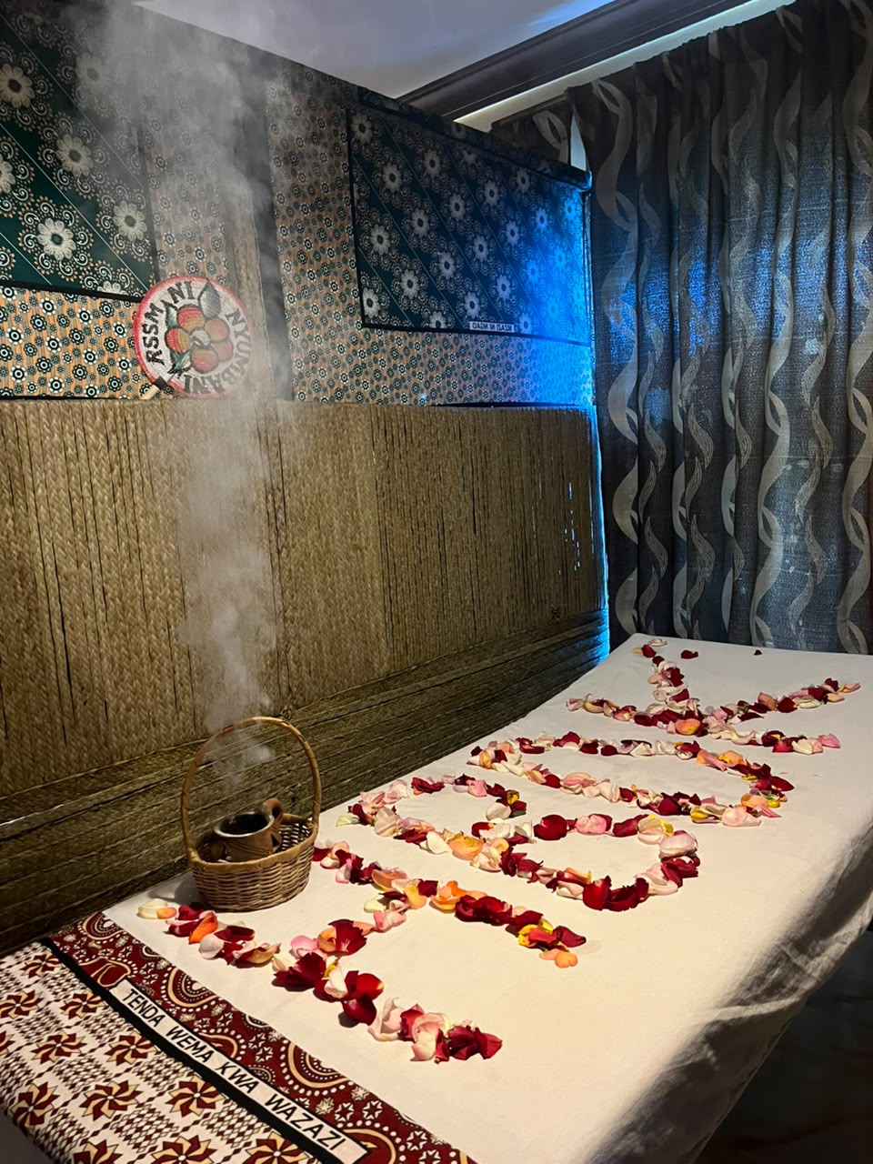 Swahili massage bed dressed with rose petals and dukhan steam